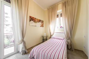 蒂沃利Tivoli Charming Houses - Domus Aefula and Domus Albula的一间卧室配有带条纹毯子的床
