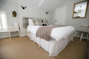查尔芬特－圣贾尔斯常春藤宾馆的卧室配有白色的床,狗坐在床上