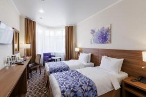 喀山雷蒙德酒店的酒店客房配有两张床和一张书桌