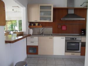 洛斯卡尼奥斯德梅卡Casa Montecote Playa的厨房配有水槽和炉灶 顶部烤箱