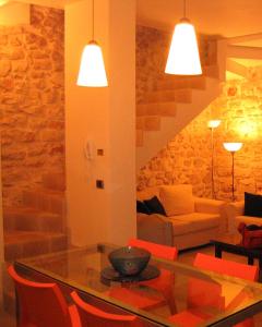 孔韦尔萨诺Lovely Stone House Conversano Puglia的客厅配有玻璃桌和红色椅子