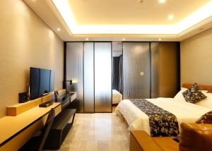 广州铂满度假公寓北京路捷登都会店的配有一张床和一台平面电视的酒店客房
