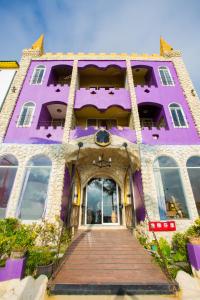 鹅銮鼻墾丁戀戀莎堡特色民宿 Castillo的一座紫色的建筑,前面设有木制走道
