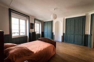 米尔库尔Les Gites Historiques的一间卧室设有绿门和床
