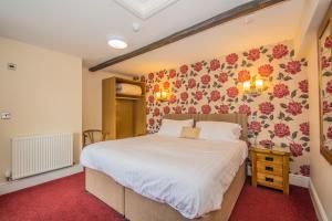 考布里奇维多利亚旅馆的卧室配有一张墙上鲜花的大床