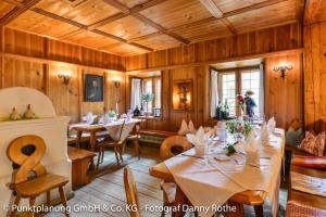 Obing奥贝维特酒店的用餐室设有木墙和桌椅