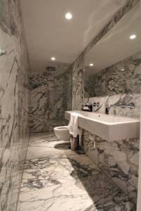 阿姆斯特丹班克酒店的大理石浴室设有水槽和卫生间