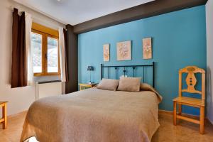卡索拉卡索拉卡斯蒂略公寓的蓝色卧室,配有床和椅子