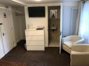 大雅茅斯大雅茅斯圣乔治酒店的小房间设有白色梳妆台和电视