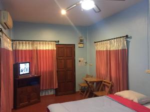 穆克莱克ฺฺ班应考度假村 的一间卧室配有一张床、一台电视和一张桌子