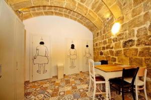 瓦莱塔Vallettastay Dormitory shared hostel的一间设有桌子和墙上两个五角形的用餐室