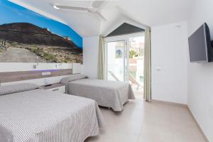 科拉雷侯TAO Caleta Playa的一间酒店客房,设有两张床和电视