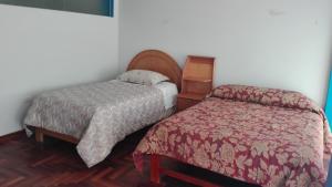 普诺Hostel Puno Backpackers的酒店客房,配有两张床和床边