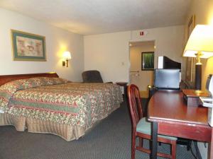 特雷霍特红地毯旅馆（原皇家旅馆）的配有一张床和一张书桌的酒店客房