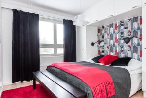奥卢Apartment Pohjanpoika的一间卧室配有一张大床和红色地毯。