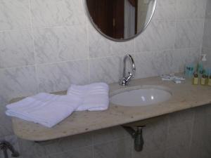 萨尔瓦多Pousada da Mércia - Itapuã (BA)的浴室配有盥洗盆、镜子和毛巾