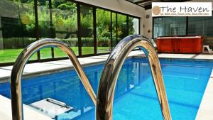 下博克特The Haven - Hotel & Spa, Health and Wellness Accommodation - Adults Only的一座房子里带金属栏杆的游泳池
