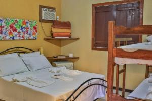 伊塔乌纳斯Pousada Das Araras的一间卧室配有一张床和一张双层床。