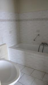 布鲁塞尔曼哈顿酒店的带浴缸的白色浴室和白色瓷砖地板。
