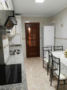 阿尔苏阿Arzúa Home的厨房配有水槽和桌椅