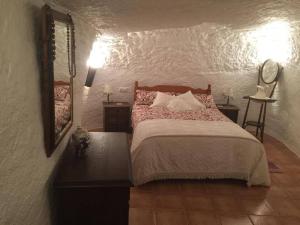 GaleraCueva Chelaja的一间卧室配有一张大床和镜子