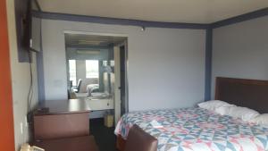 沙伦维尔旅游酒店的一间卧室配有床、水槽和镜子