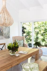 拜伦湾Satara Byron Bay - Adults Only的客厅设有木桌和大窗户。
