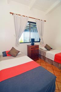 维拉港太平洋泻湖公寓酒店的一间卧室设有两张床和窗户。