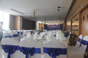 荣市Muong Thanh Cua Dong Hotel的配有一张桌子、白色椅子和蓝色弓箭的房间