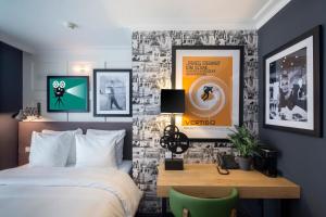 阿姆斯特丹高地之家酒店的一间卧室配有一张床、一张书桌和海报
