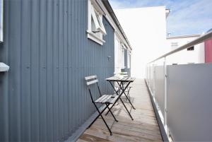 雷克雅未克Odinn Reykjavik Odinsgata Apartments的两把椅子坐在建筑物旁边的甲板上