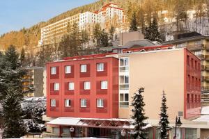 莱森阿尔卑斯经典酒店的山前的红色建筑