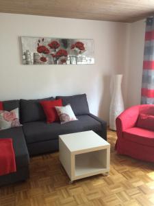 Illschwang格鲁恩公寓的带沙发和红色椅子的客厅