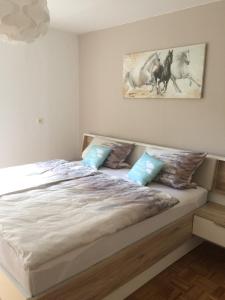 Illschwang格鲁恩公寓的卧室配有带蓝色枕头的大型白色床