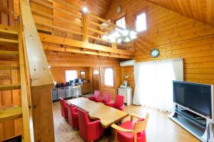 小樽樱花园山林小屋的一间带桌子和红色椅子的用餐室