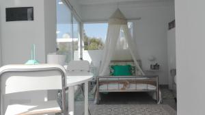 卡列罗港Apartamento Calero的白色的客房配有桌椅和窗户。