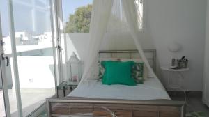 卡列罗港Apartamento Calero的一张带绿枕头的天蓬床