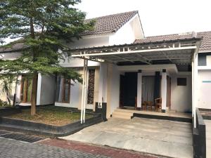 日惹诺拉度假屋的白色的房子,有门廊和树