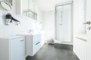青斯特Hotel Boddenhus Garni的白色的浴室设有2个盥洗盆和淋浴。