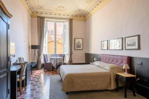 锡耶纳La Terrazza Sul Campo-Rooms Only的一间卧室配有一张床、一张桌子和一个窗户。