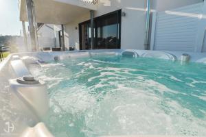 格赫伦-莱宾Villa Fleesenstrand的设有一个蓝色水的按摩浴缸