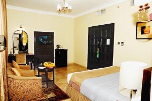 阿布扎比皇家半岛酒店的酒店客房设有床和客厅。