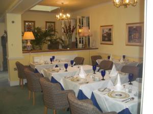 雷丁比奇豪斯酒店的用餐室配有桌椅和白色桌布