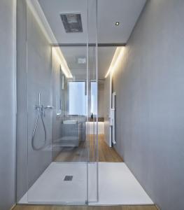 里乔内Luxury Suites Collection - Frontemare Viale Milano 33的带淋浴的浴室和玻璃门