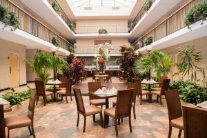蒙特雷华丽蒙特利酒店的一间设有桌椅的餐厅,种植了植物