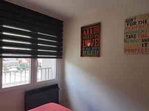 安道尔城巴里安蒂克旅馆&酒吧的一间卧室,配有带黑色百叶窗和标志的窗户