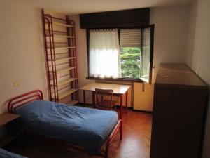 托尔博莱曼德利公寓的一间卧室配有一张床、一张书桌和一个窗户。