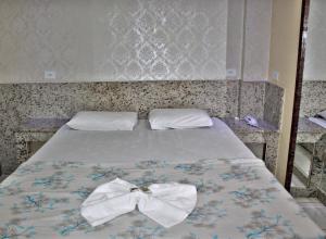 马瑙斯大巴拉灯塔酒店的一张床上有两条弓形的领带