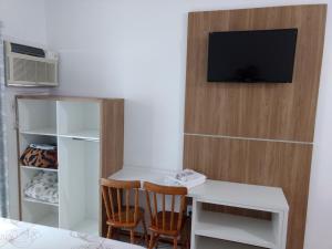 伊塔佩马波萨达泰拉索尔旅馆的客房设有书桌和墙上的电视
