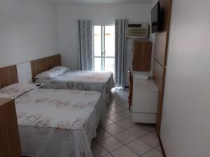 伊塔佩马波萨达泰拉索尔旅馆的小房间设有两张床和一台冰箱